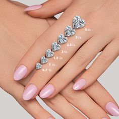 a woman's hand with pink manies and diamond rings on her fingers, showing the size