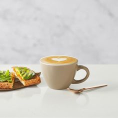 a cup of cappuccino next to a piece of toast