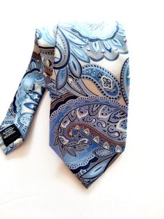 Classic and elegant Perry Ellis American designer tie, will add lots of charm to your outfit. Blue paisley design on a light grey background looks fresh and stylish. You can wear it casually and for any special occasion like engagement and wedding celebration. The tie is 100% silk and in mint condition. It will certainly make a beautiful gift too! The tie comes in a gift wrap and with a 'Thank you' card. For more items in my store visit: https://www.etsy.com/ca/shop/NostalgicByLiliya For more ti Blue Paisley Print Tie For Black Tie Events, Blue Paisley Print Ties For Black Tie Events, Blue Paisley Print Ties For Black Tie Occasion, Blue Paisley Print Standard Tie, Blue Paisley Print Tie, Blue Paisley Print Ties For Business, Blue Paisley Print Business Ties, Elegant Patterned Ties With Paisley Print, Blue Paisley Print Suit And Tie Accessories