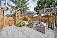 an outdoor living area with patio furniture and umbrellas