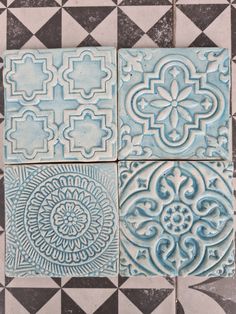 four blue and white tile designs on the floor