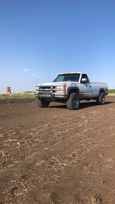 the truck is parked on the dirt road