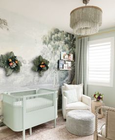 a baby's room decorated in pastel green and white with flowers on the wall