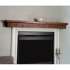 a white fireplace with a shelf above it