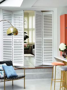 a living room filled with furniture and white shutters