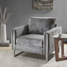 a gray chair sitting next to a glass table