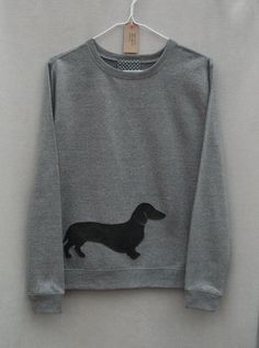 a gray sweatshirt with a black pug on it hanging from a clothesline hanger