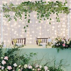 the table is set up with flowers and greenery for an outdoor wedding reception at night