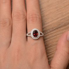 It is a natural garnet ring. The main stone is 6mm*8mm oval cut, weight about 1.73 carats. The basic metal is sterling silver and plated with rhodium. To change the metal to a solid gold (white/rose) or platinum is also available, please ask for a quotation if you want. You can also go to my shop Home for more elegant rings: https://www.etsy.com/shop/godjewelry?ref=hdr_shop_menu More garnet rings: https://www.etsy.com/shop/godjewelry?ref=seller-platform-mcnav&section_id=20709242 Customizatio Rainbow Topaz Ring, Wedding Rings Emerald Cut, Oval Halo Engagement Ring, Red Gemstone Ring, January Birthstone Rings, Double Halo Engagement Ring, Sterling Silver Garnet Ring, Mystic Topaz Ring, Sterling Silver Engagement Rings