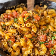 a skillet filled with pasta and meat