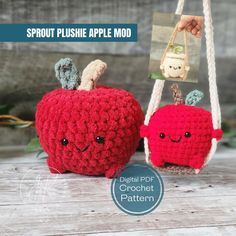 two crocheted apples hanging from strings with faces drawn on them and the words sprout plushe apple mod