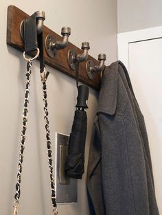 a coat rack with two umbrellas hanging from it's hooks and some coats