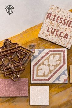 various tile pieces on a wooden table with the words dissesore lucia written in spanish