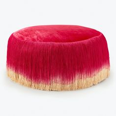 a pink and yellow poufle sitting on top of a white floor