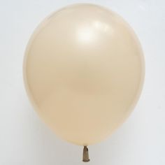 a large white balloon is floating in the air on a string attached to a wall