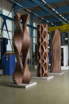 three large wooden sculptures sitting inside of a building