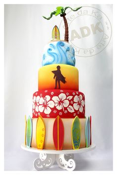 a multi layer cake decorated with surfboards and a palm tree