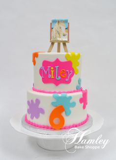 a three tiered cake with an easel on top