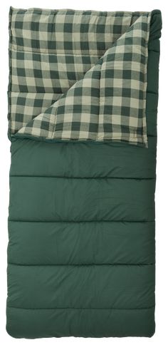 the green and white checkered sleeping bag is folded up on top of a pillow