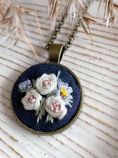 This hand embroidered pendant features a delicate floral design. The perfect accessory for you, or a great gift idea for a loved one. A beautiful and unique conversation piece. Each piece is unique. The design is set in an antique gold pendant and comes with either a 20 inch or 22 inch chain. Note that this is a handmade item. Actual colors may vary. Due to light and screen display the colours might be shown slightly different. *PLEASE NOTE* ITEM DETAILS - pendant measures 1" x1" - chain: 20" or Bohemian Jewelry With Floral Embroidery For Gifts, Embroidered Pendant Necklace For Gift, Antique Gold Pendant, Hand Embroidered Pendant, Jewelry Embroidery, Embroidery Pendant, Hand Embroidered Necklace, Hand Embroidered Jewelry, Embroidered Pendant