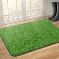 a pair of rubber boots sitting on top of a green rug in front of a door