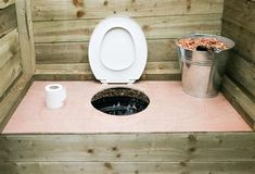 there is a toilet and trash can in the sauna