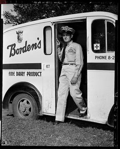 an old photo of a man standing in the door of a truck