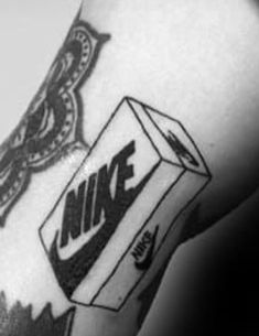 a black and white photo of a person's arm with a nike tattoo on it