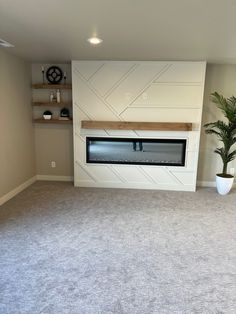 an empty room with a fireplace and shelves