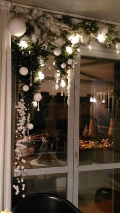 the window is decorated with white balls and greenery