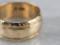 This wide vintage band is crafted entirely of 14k yellow gold. The center of this ring is slightly domed, giving it the ability to catch the light, and is accented by the masculine carvings on the edge. Metal: 14K Yellow Gold Width of Band: 7.8 mm Height off Finger: 1.5 mm Ring Size: 6 Marks: "A14K" Stamped on the inside band Vintage Band, On The Edge, Gold Band, Eternity Bands, The Edge, Gold Bands, Cuff Bracelets, Ring Size, Wedding Rings