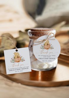 a glass jar filled with marshmallows sitting on top of a wooden table