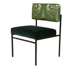 a green velvet chair with an ornate design on the back