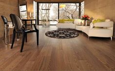 a living room filled with furniture and a large window overlooking the trees in the distance