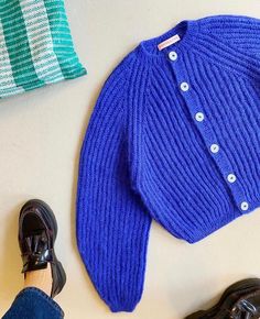 a pair of shoes and a blue sweater on a table