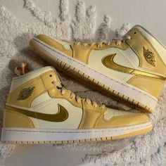 Wmns Air Jordan 1 Mid Se Pale Vanilla/Metallic Gold Vanille Pale/Or Metallique Sporty Gold High-top Jordan Shoes, Gold Shoes Sneakers, Jordan Mids, Jordan Gold, Jordan 1 Low White, Wmns Air Jordan 1, Air Jordan 1 Mid Se, Air Jordan 12 Retro, Jordan 1 High Og