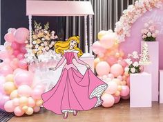 there is a princess standing in front of some balloons and flowers on the floor at a party