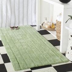 a bathroom with black and white checkered flooring, shower curtain and rugs