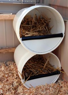 the three tiered bucket nesting boxes are filled with hay and straw, as well as