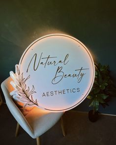 a lighted sign that says natural beauty aesthetics on the side of a chair next to a potted plant