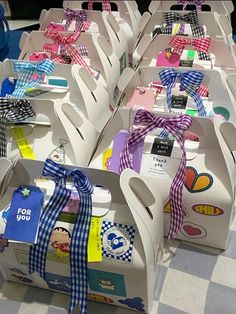 several boxes with different designs and ribbons tied around them on a checkered tablecloth