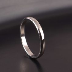 a wedding ring sitting on top of a black surface with no one in the photo