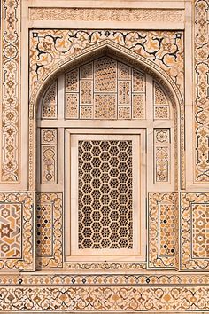 an intricately decorated window in the middle of a white and gold building with ornate designs