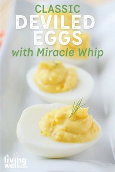 three deviled eggs with mayonnaise whip in them on a white platter