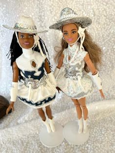 two dolls are standing next to each other wearing hats and dresses with sequins on them