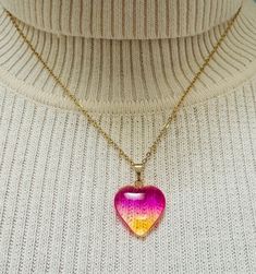 Add a touch of whimsy and color to your outfit with this stunning Gradient Heart-shaped Glass Pendant on 18K Gold Plated Chain! Featuring beautiful ombré colors in shades of pink/ yellow (Warm Blush), purple/ green (Aurora Borealis), purple/ blue (Night Sky), red (Rose) and black (Midnight), this unique pendant is sure to stand out.   An 18k gold-plated stainless-steel chain completes the look. Perfect for adding a pop of color to any look, this necklace makes for a truly special gift idea for yourself or a loved one. Handmade with care, this glass heart necklace is great for any occasion and ready to add that extra flair to your jewelry collection. Product info: *Glass heart pendant is ~2 cm x ~2 cm *18k gold plated stainless steel link cable chain necklace fully extended is ~18 inches *H Yellow Heart-shaped Jewelry For Valentine's Day, Trendy Yellow Gold Heart Necklace, Pink Heart-shaped Glass Jewelry, Pink Heart-shaped Resin Jewelry, Rainbow Heart Necklaces As Gifts, Heart-shaped Pink Glass Jewelry, Heart-shaped Rainbow Necklace For Gift, Trendy Rainbow Heart-shaped Jewelry, Resin Heart Charm Pendant Jewelry