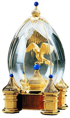 an ornate glass and gold clock with blue beads