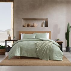 a bedroom with a large bed covered in a light green comforter