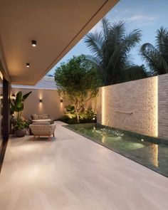 an indoor swimming pool with lights on the side and palm trees in the back ground