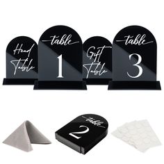 the table numbers are black and white with silver lettering on each one, along with matching napkins